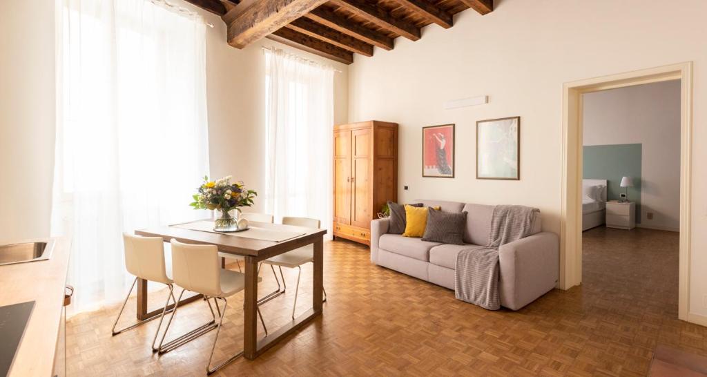 ein Wohnzimmer mit einem Tisch und einem Sofa in der Unterkunft Charming JOIVY Flat Next to Duomo di Como in Como