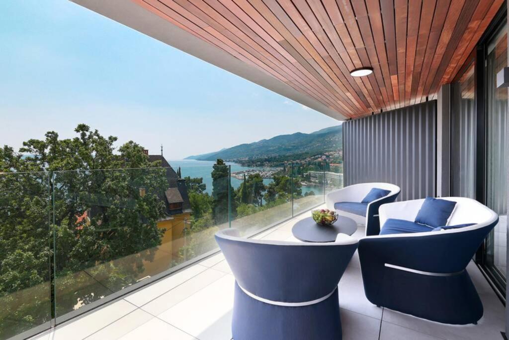 uma varanda com 2 cadeiras e vista para o oceano em Marena - Trees to Seas Luxury Escape em Opatija