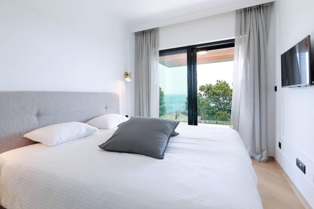 sypialnia z białym łóżkiem i dużym oknem w obiekcie Marena - Trees to Seas Luxury Escape w mieście Opatija