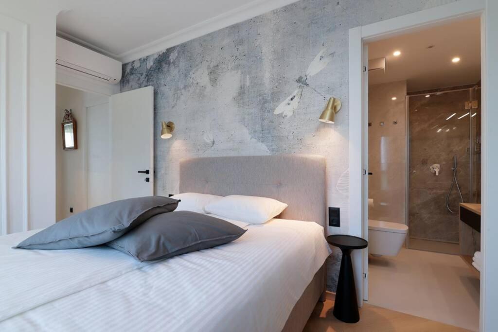sypialnia z białym łóżkiem i łazienką w obiekcie Marena - Trees to Seas Luxury Escape w mieście Opatija