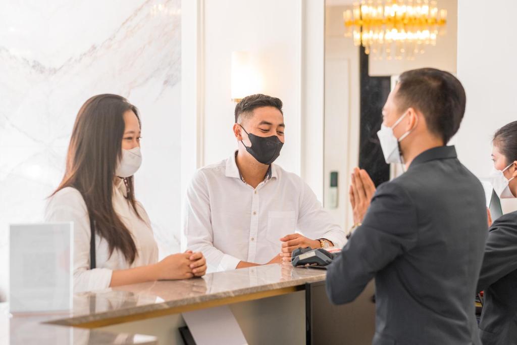 a group of people standing around a table wearing masks at Kala Hotel Semarang in Jomblang