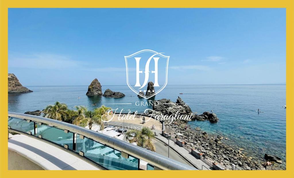 ein Schild für ein Resort am Strand mit Meerblick in der Unterkunft Grand Hotel Faraglioni in Acitrezza