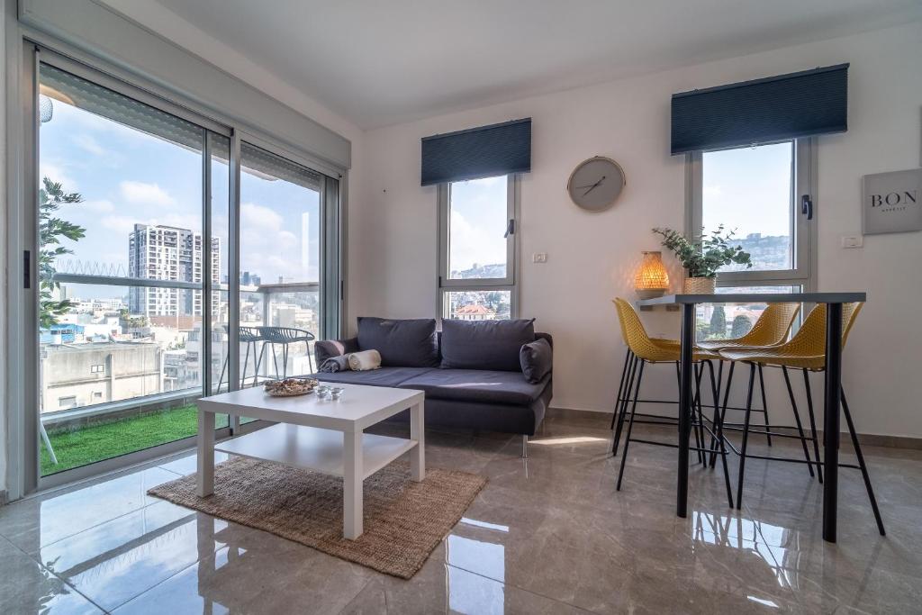 ein Wohnzimmer mit einem Sofa und einem Tisch in der Unterkunft PORT CITY HAIFA - German Colony Luxurious 2 bdrms Apt in Haifa