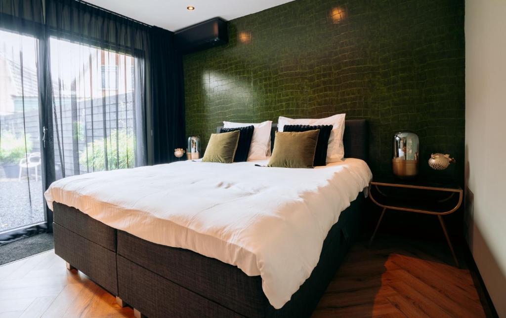 a large bed in a room with a brick wall at B&B Bardot in Purmerend