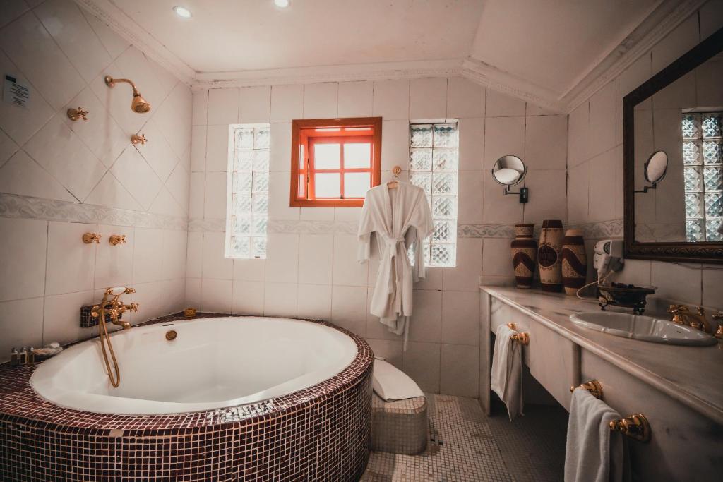 a bathroom with a large tub and a sink at Pousada de Charme Vila Natal - Exclusive Boutique in Campos do Jordão