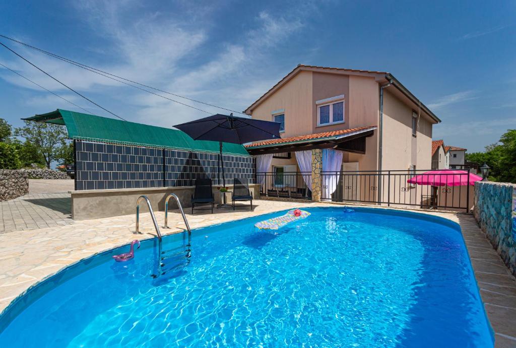 a swimming pool in front of a house at Apartment With A Private Swimming Pool, Garden & BBQ in Gostinjac