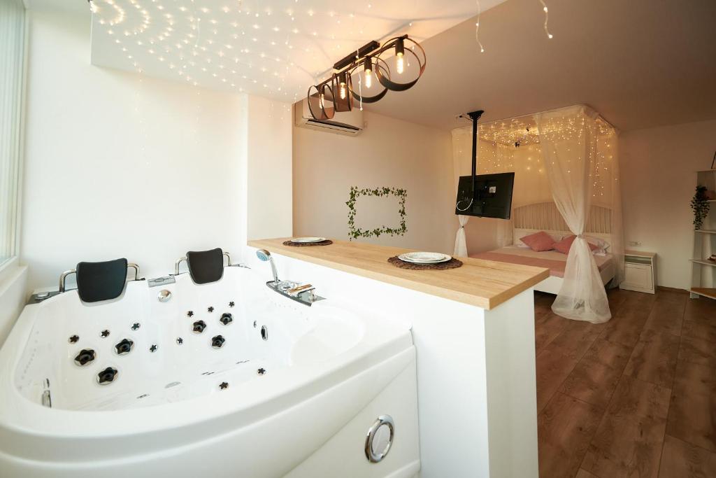 a bathroom with a white tub and a sink at Romantic Studio in Braşov