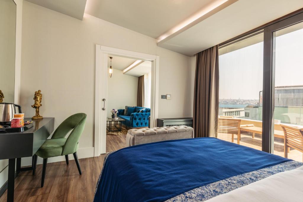 a hotel room with a bed and a desk and a balcony at Union Hotel Port in Istanbul