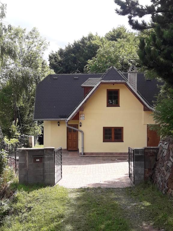 a white house with a black roof and a driveway at Domček pod Starým mestom in Banská Štiavnica