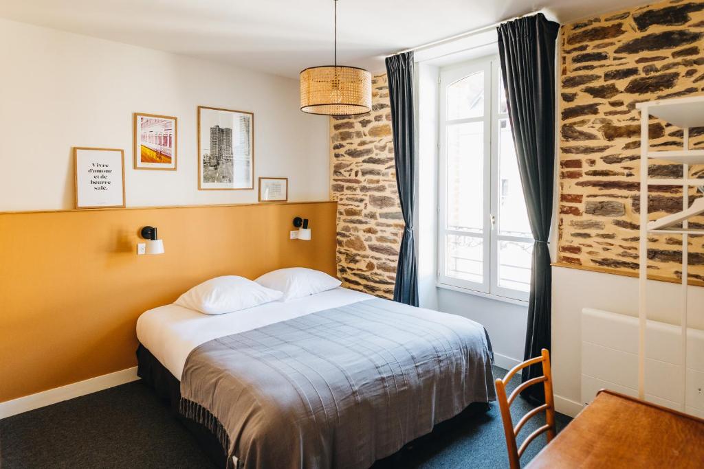 Les Chouettes Hostel في رين: غرفه فندقيه بسرير ونافذه