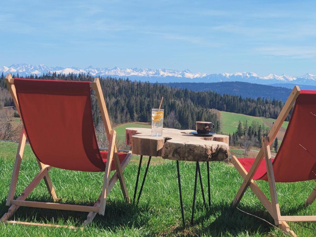two chairs and a table with a drink on it at Wrzosowy Dwór - SPA in Skomielna Czarna