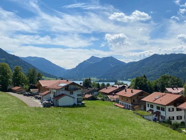 a small village with houses and mountains in the background at Apartment Schlierseeblick - ruhig mit tollem See- und Bergblick in Schliersee