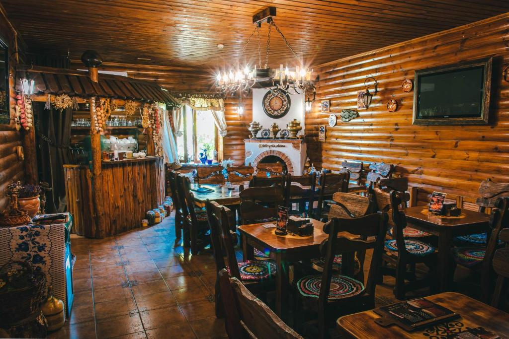 a restaurant with tables and chairs and a fireplace at Spa-hotel Dobrynia in Odesa