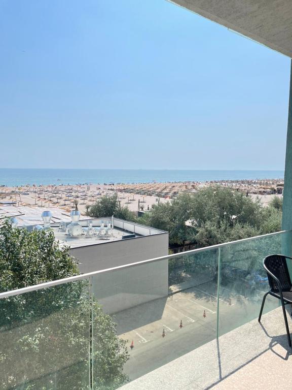 a balcony with a chair and a view of the beach at Studio Crazy Beach Summerland in Mamaia
