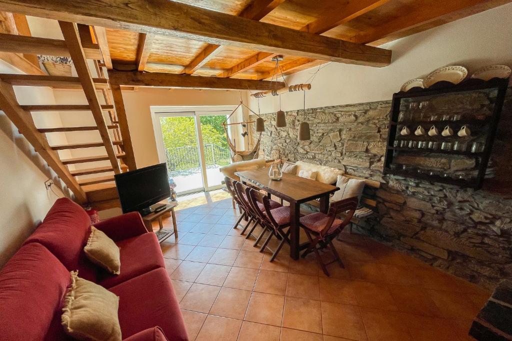 a living room with a table and a stone wall at Casa Rural As Bodegas - Boal in Boal