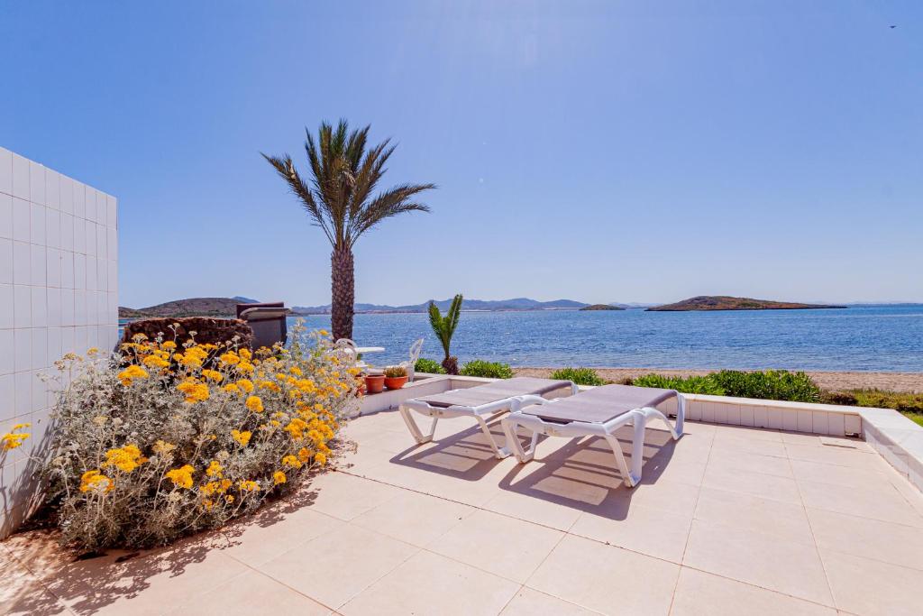 d'une terrasse avec une table et des chaises au bord de l'eau. dans l'établissement Soling 9, à La Manga del Mar Meno