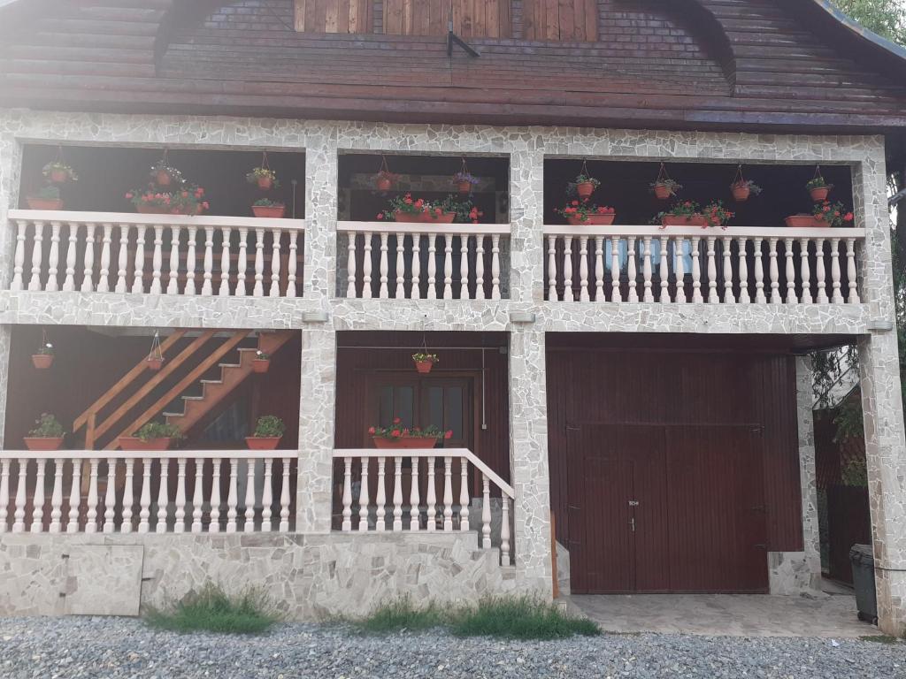 a building with a porch and stairs on it at Casa Roberta in Arieşeni