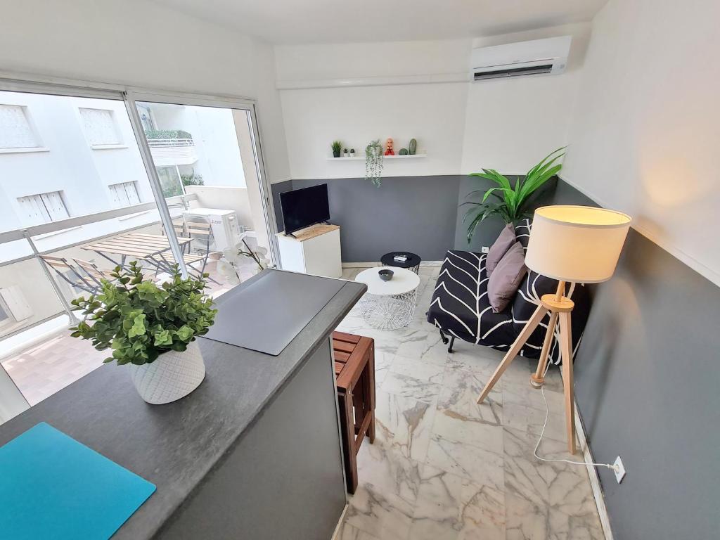 a living room with a desk and a couch at GregBnb-com - T2 Pleine Ville - CLIMATISE - BALCON - 1 in Toulon