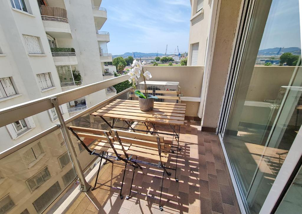 a balcony with a wooden table and a bench at GregBnb-com - T2 Pleine Ville - CLIMATISE - BALCON - 1 in Toulon