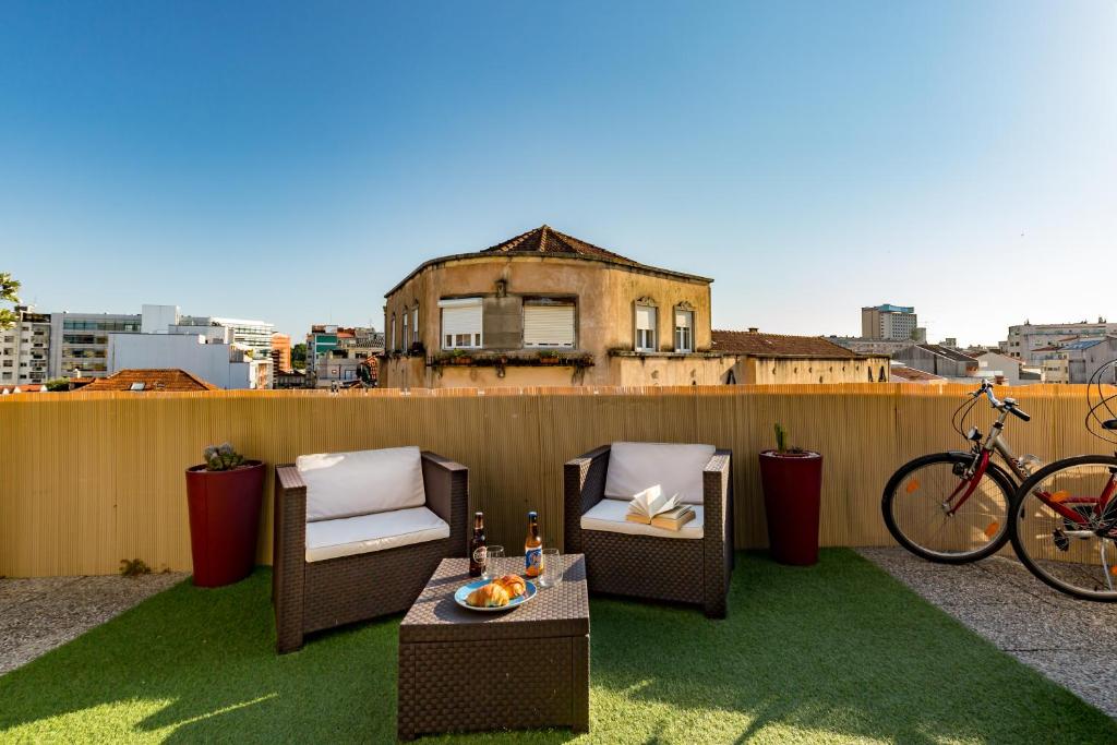 a patio with two chairs and a table and a bike at Music Relaxing Apt with bikes, terrace & parking in Porto