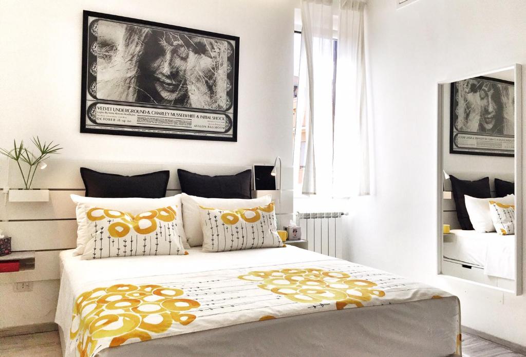 een slaapkamer met een groot bed met gele en witte kussens bij PIGNETO VILLAGE Roma Guest House Apartment in Rome