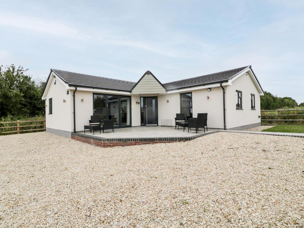 a detached house with a patio and gravel driveway at Strawberry Stables in Bristol