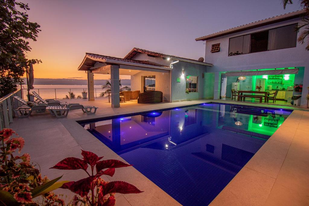 a swimming pool in front of a house at Pousada Refúgio das Estrelas - Vista para o Mar in Ilhabela