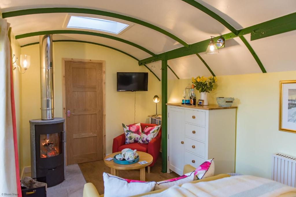 een woonkamer met een houtkachel in een kamer bij Plumcot Halt by Bloom Stays in Canterbury