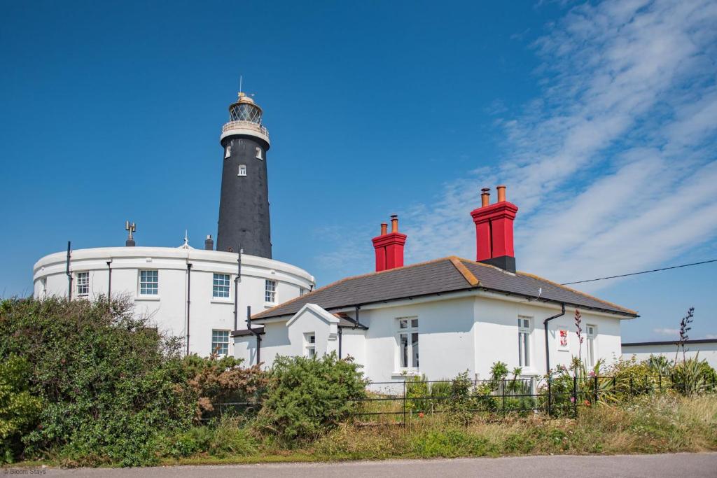 ein Leuchtturm auf einem weißen Gebäude in der Unterkunft East Cottage by Bloom Stays in Dungeness