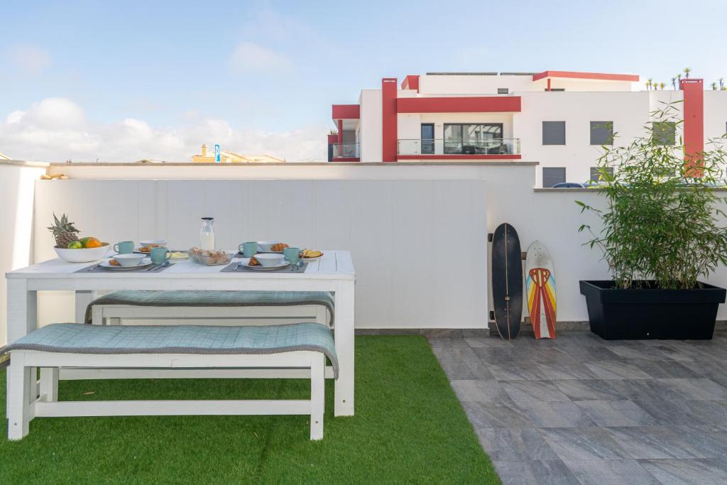 a white table and bench on a patio at Swell House in Ferrel