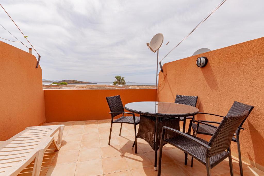 a patio with a table and chairs on a balcony at Soling 80 in La Manga del Mar Menor