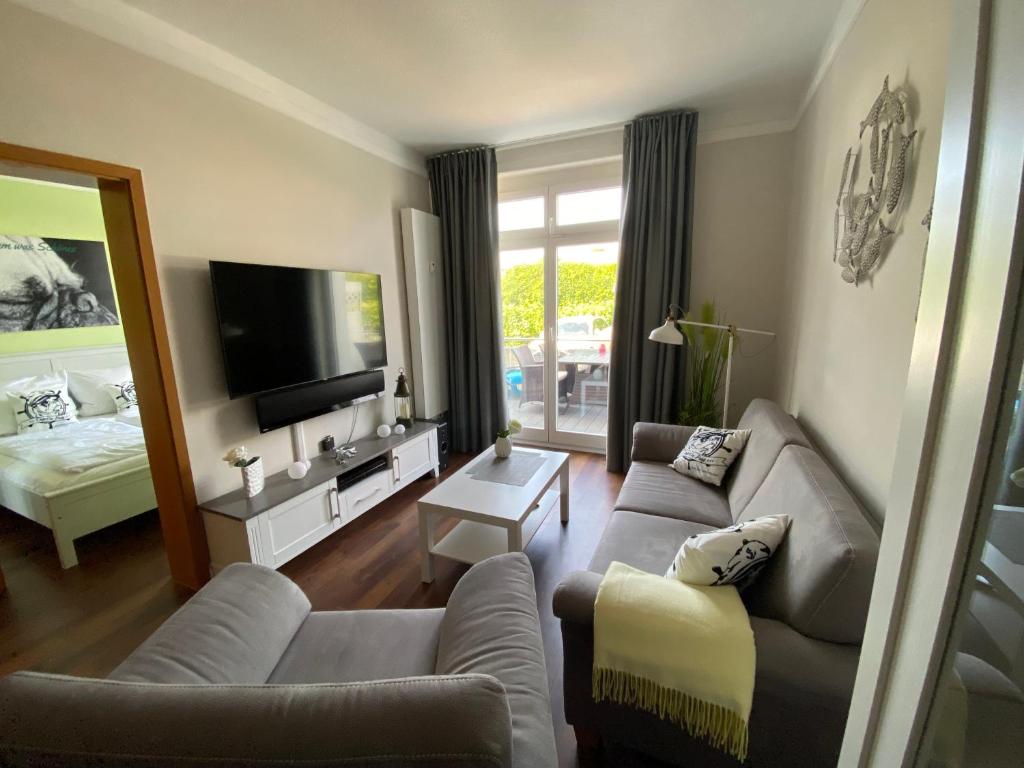 a living room with a couch and a tv at Ferienwohnung Käpt'n Pugs Kajüte auf Rügen in Göhren