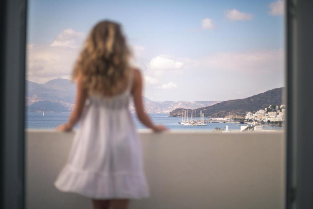 een klein meisje in een witte jurk op een muur bij Hotel Ippocampos Studios in Adamas