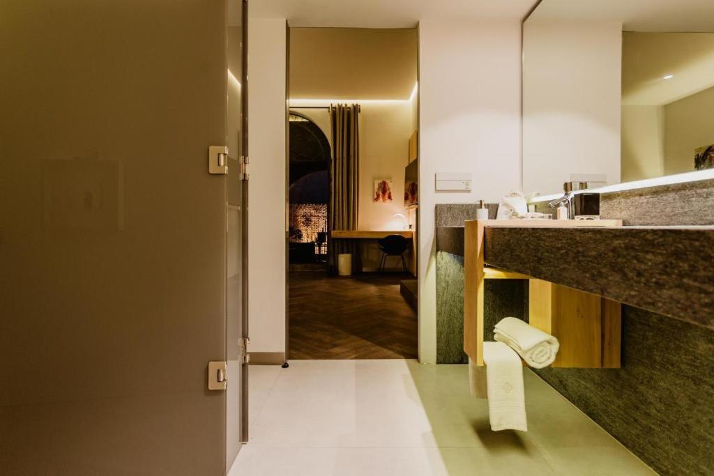 Baño con una puerta que conduce a una habitación en Tá Hotel de diseño en Querétaro