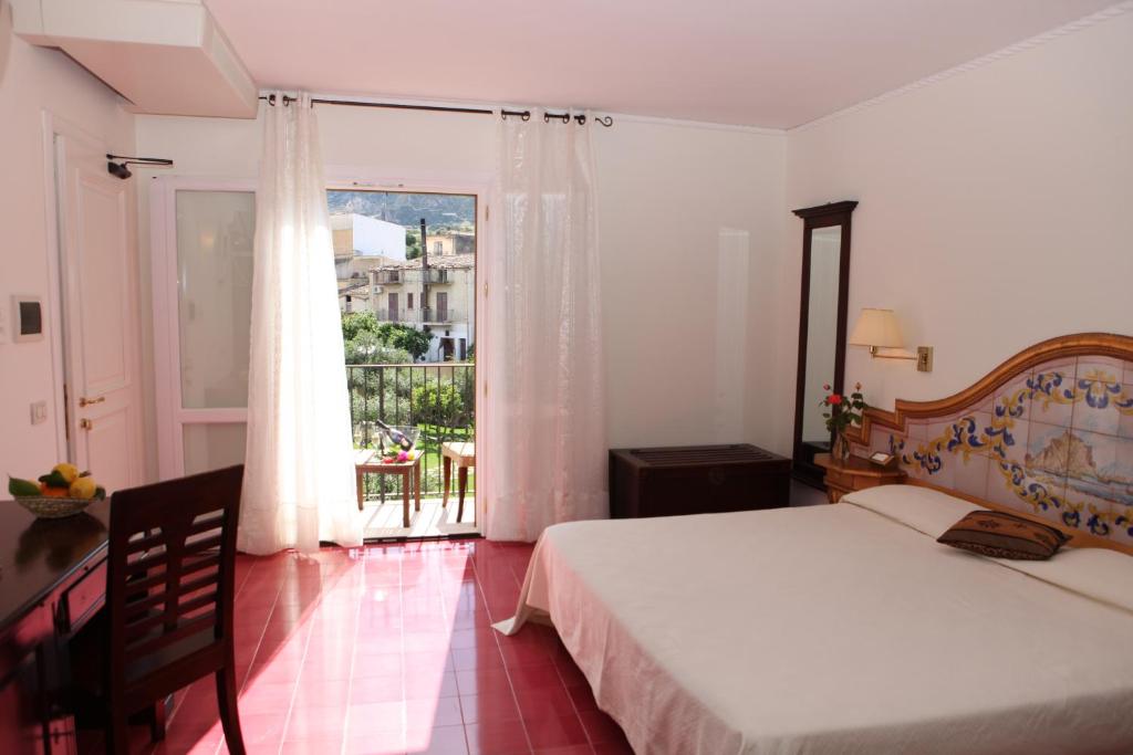 a bedroom with a bed and a large window at Torre Bennistra in Scopello