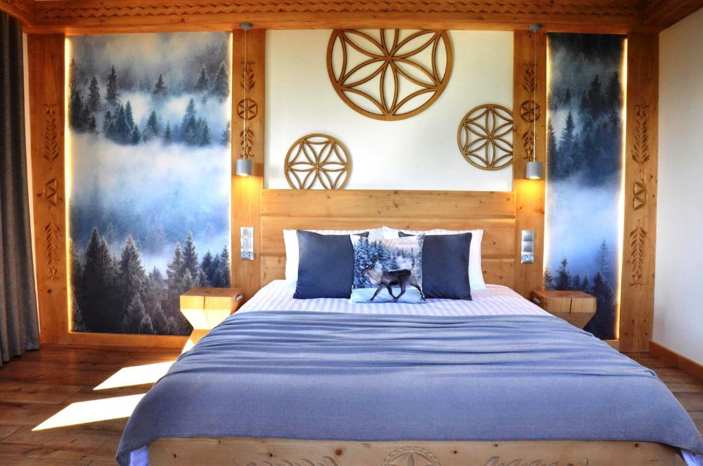 a bedroom with a large bed with blue pillows at TATRY NA WYPASIE in Czerwienne