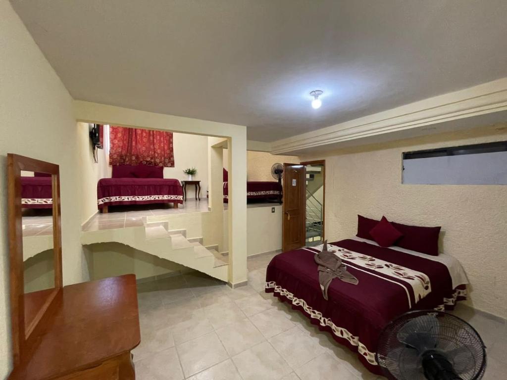 a bedroom with a bed and a staircase with a mirror at Casa de Hu&eacute;spedes May in Ixtapan de la Sal