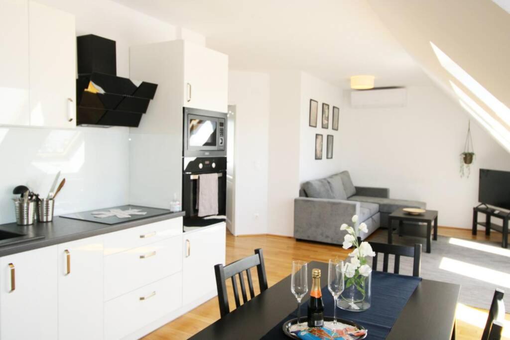uma cozinha e sala de estar com uma mesa e um sofá em Penthouse near Schoenbrunn Amazing Terrace Apt.42 em Viena