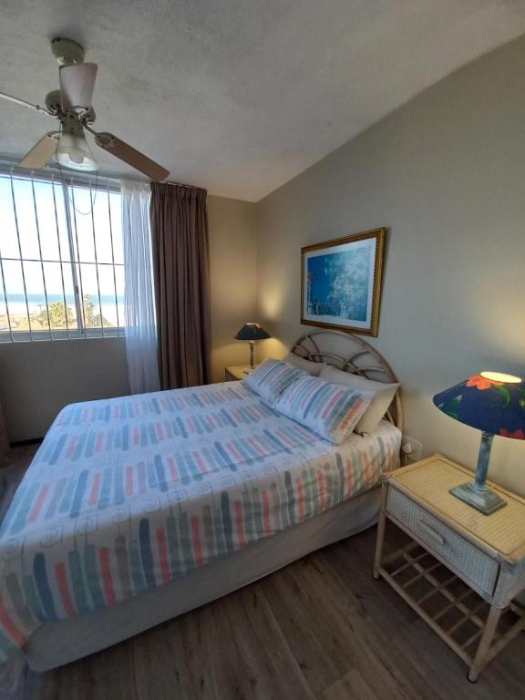 um quarto com uma cama, um candeeiro e uma janela em Margate Boulevard - Superb Secure Apartment em Margate