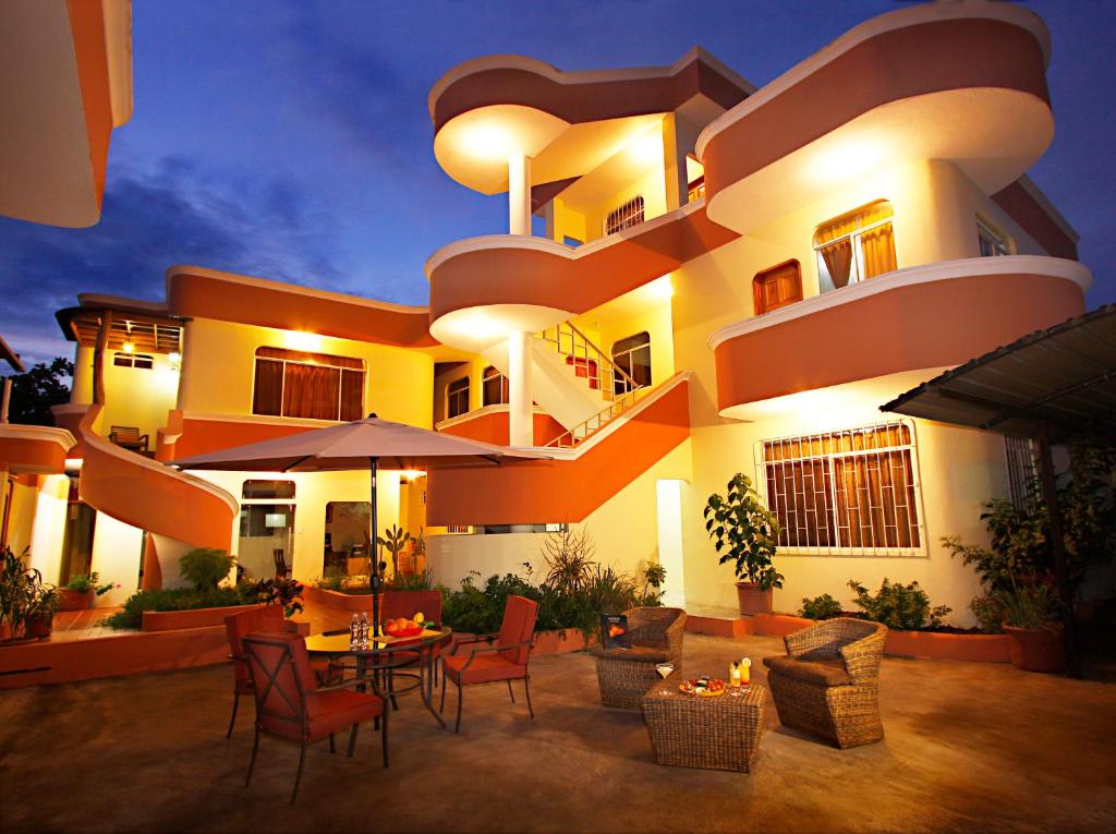 a large building with chairs and tables in front of it at Hotel Del Sol Galapagos in Puerto Ayora