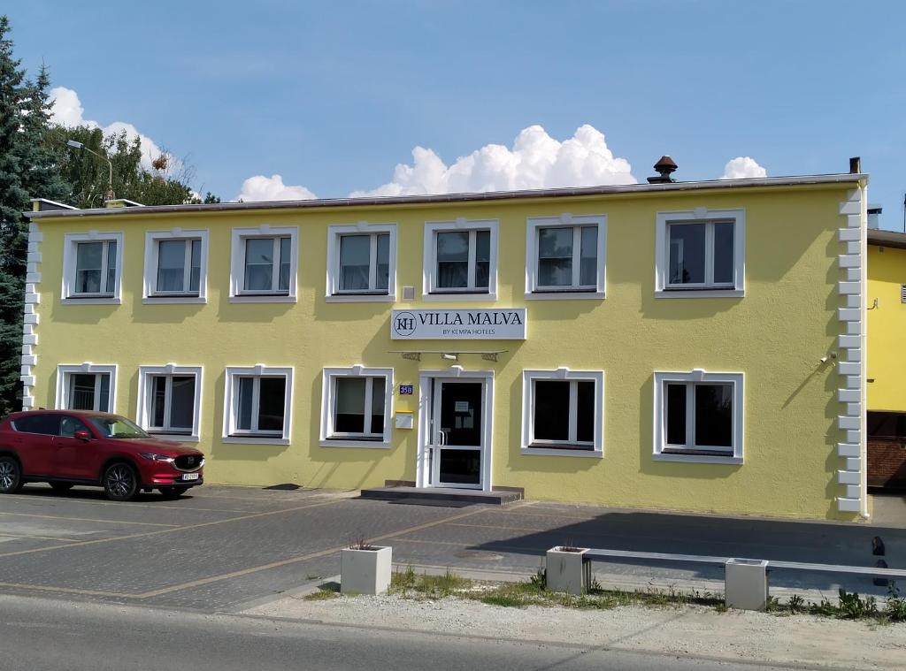 a yellow building with a sign that reads visitor marker at Villa Malva in Łomianki