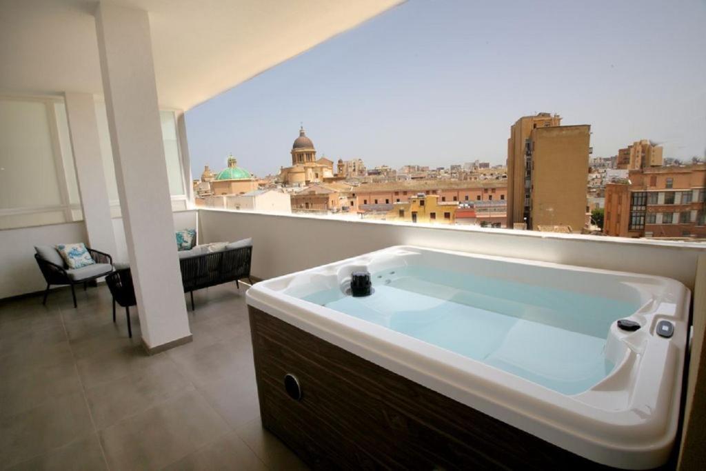a bath tub in a room with a view of a city at Dimora Mothia in Marsala