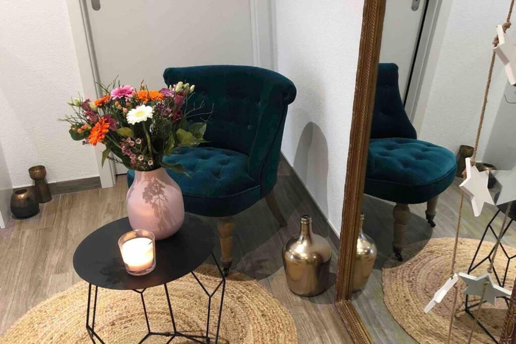 a vase of flowers on a table with a candle at Beautiful Cocoon in Neuchâtel