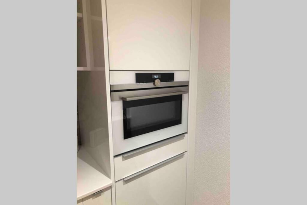 a kitchen with an oven in a white cabinet at Beautiful Cocoon in Neuchâtel