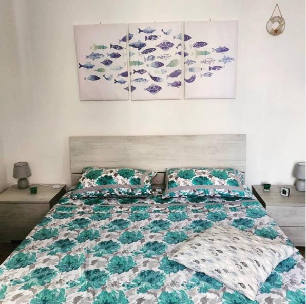 um quarto com uma cama com uma colcha verde e branca em The Beach House em Lavagna