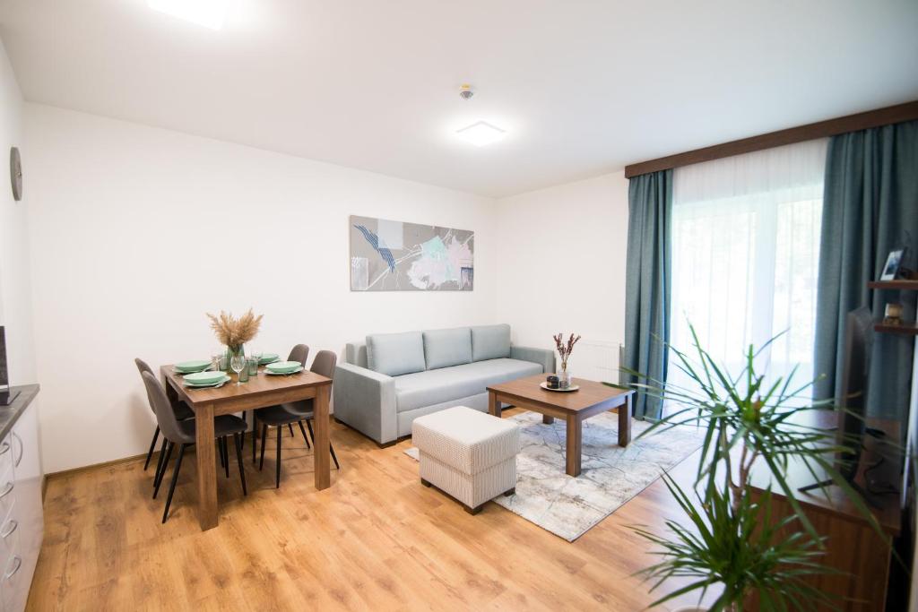 ein Wohnzimmer mit einem Sofa und einem Tisch in der Unterkunft Galeria Apartments in Demänovská Dolina