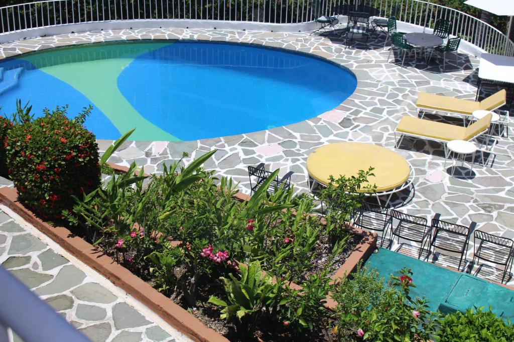una piscina con due sedie e un patio di Hermosa Residencia Costa Azul Acapulco ad Acapulco