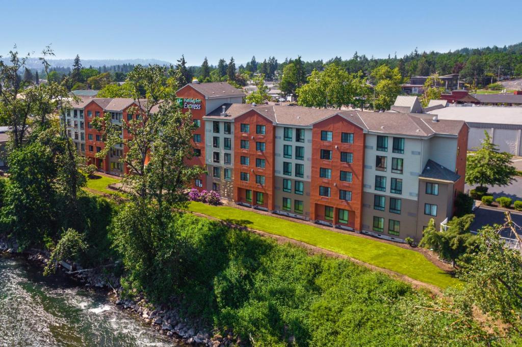 a group of buildings on a hill next to a river at Holiday Inn Express Portland SE - Clackamas Area, an IHG Hotel in Gladstone