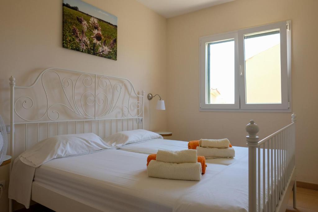 a bedroom with a white bed with two towels at Casa Nani in Sa Ràpita