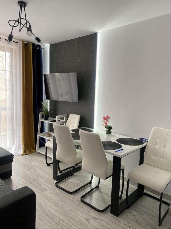 a living room with a dining room table and chairs at Nowoczesny Apartament Nad Łomnicą in Karpacz